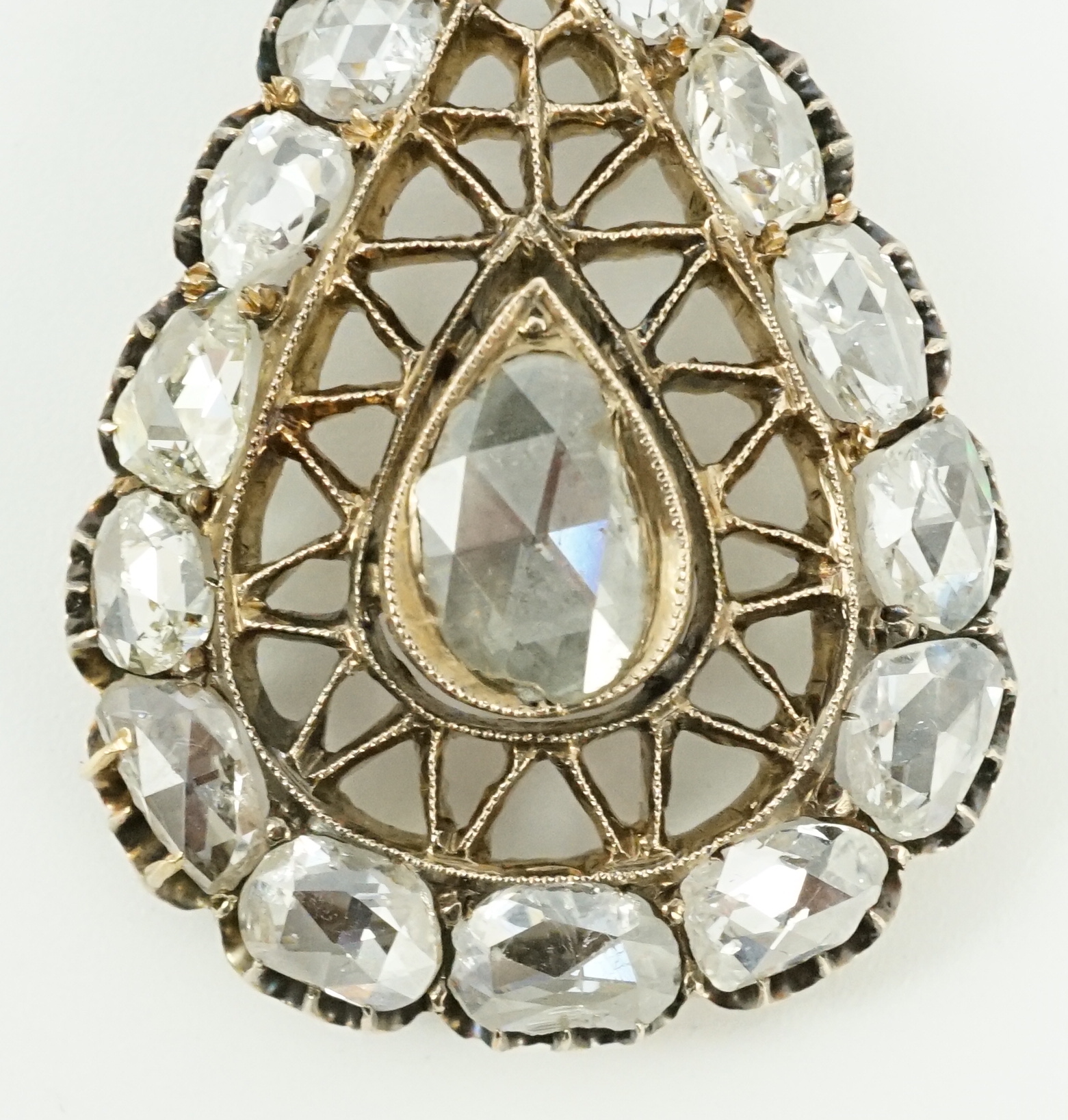 An early 19th century gold and rose cut diamond cluster set pear shaped drop pendant, with ribbon bow bale